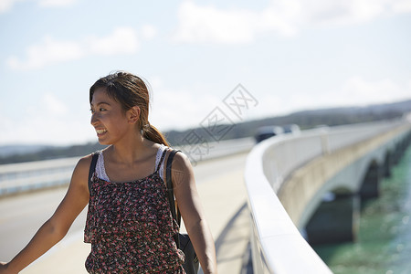 旅途中的女性走在海面大桥上高清图片