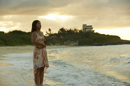  站在海边的女性弹乐器
图片