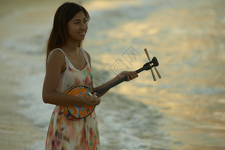  海边弹吉他的女性图片