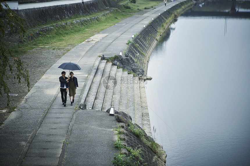 夫妇旅行雨中漫步照图片