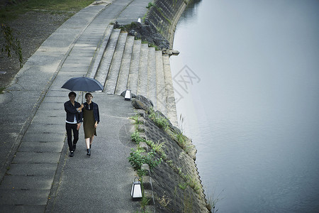 夫妇旅行雨中漫步照图片