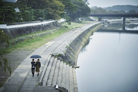 夫妇旅行雨中漫步照图片