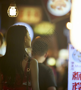 在夜市逛街的女游客背影图片