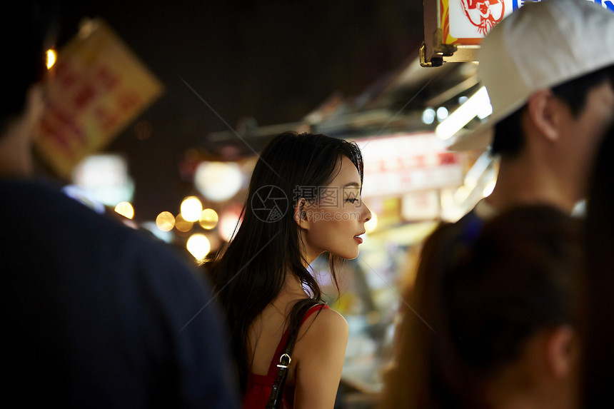 在夜市逛街的女游客图片