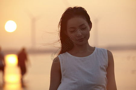 日落时分走在海滩边上长裙美女高清图片