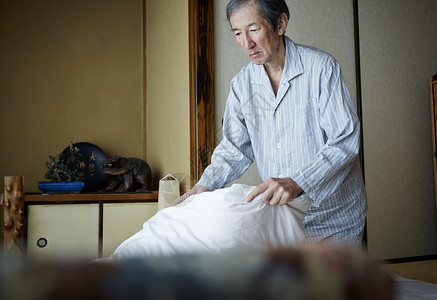 在叠被褥的老年男人图片