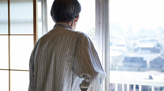 独居老人穿着睡衣打开窗户向外看图片