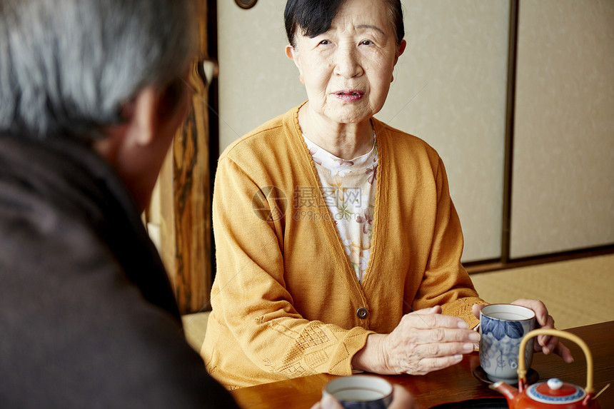 一对老年夫妻在起居室喝茶聊天图片