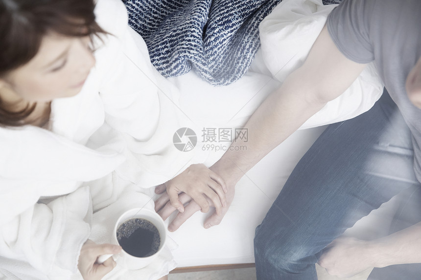 女人端着咖啡握着男友的手图片