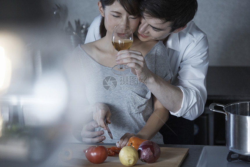 端着酒杯的男人喂切菜的女人喝酒图片