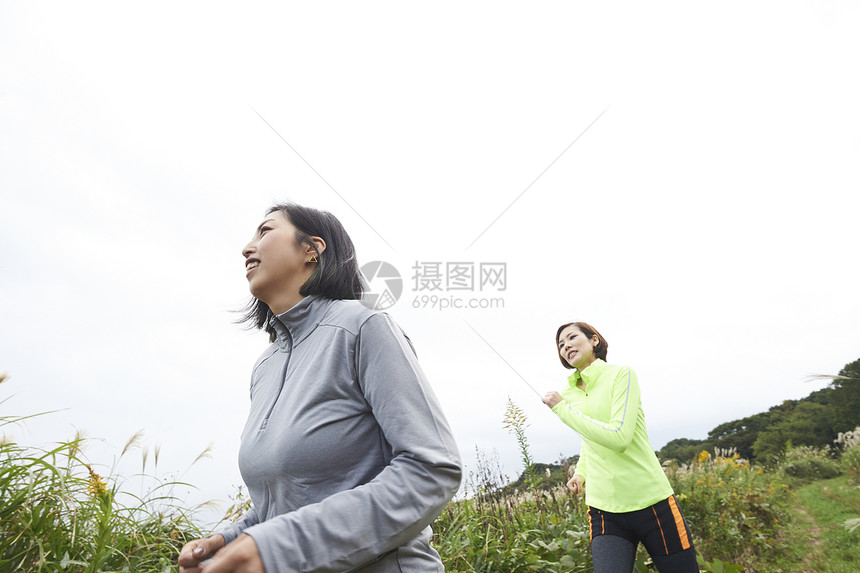 两个个在田间小路跑步的女人图片