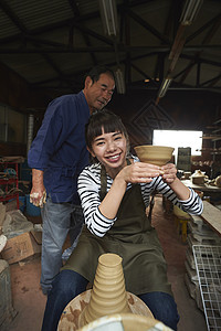 陶瓷师傅指导体验陶瓷制作的女人图片