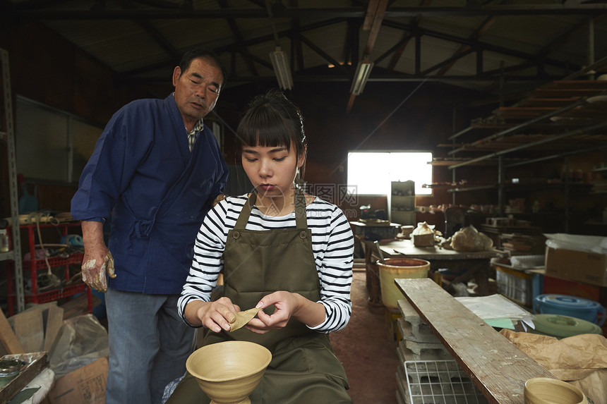 陶瓷师傅指导体验陶瓷制作的女人图片
