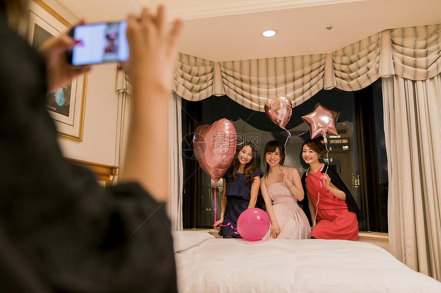 年轻女孩子们在酒店派对拍照留念图片