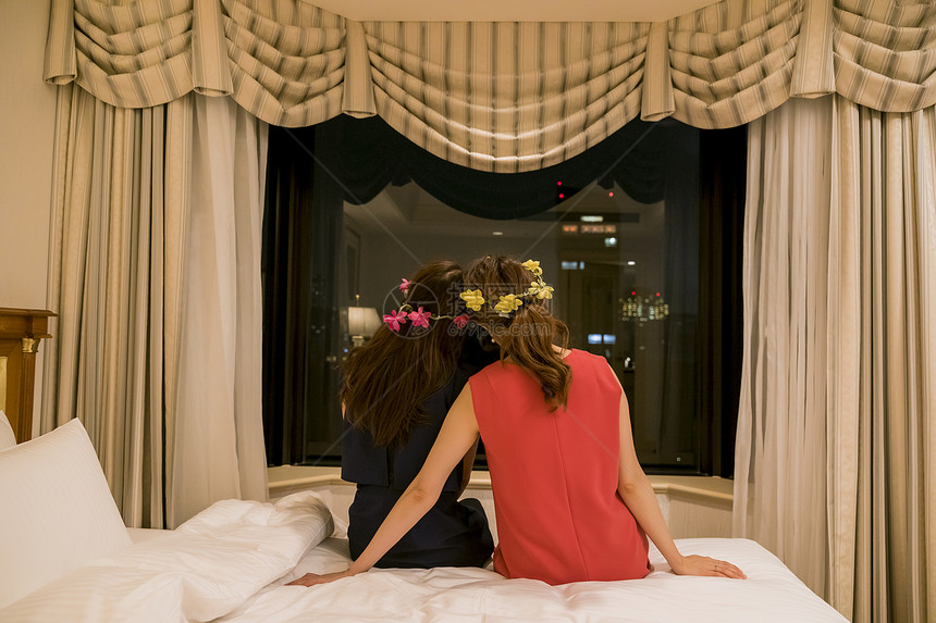 坐在床上带着花环的女孩们图片