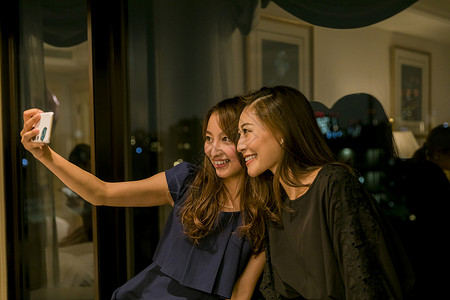 朋友聚会两个女人在窗边自拍图片