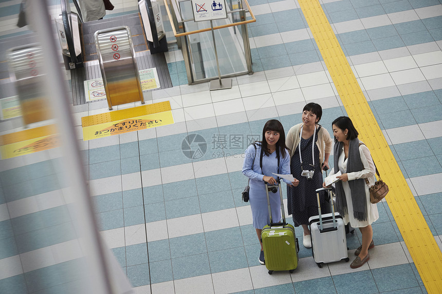 航站楼里拖着行李的三名女性图片