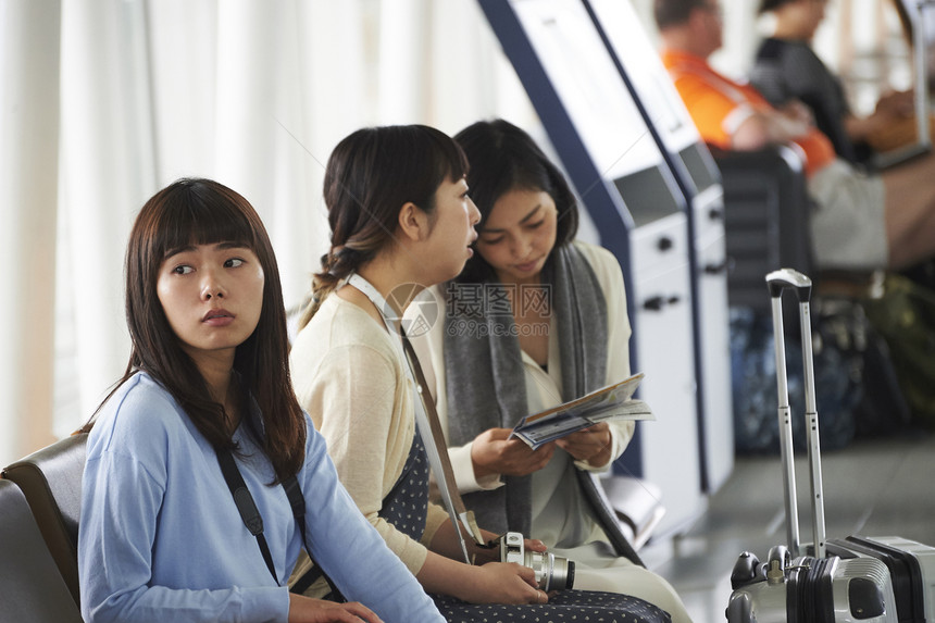 带着行李坐在航空站候车室的女人们图片