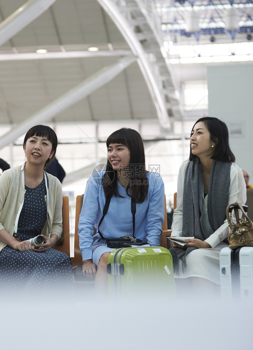 带着行李坐在航空站候车室的女人们图片