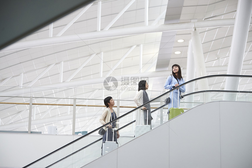 带着行李站在航空站扶梯上的女人们图片