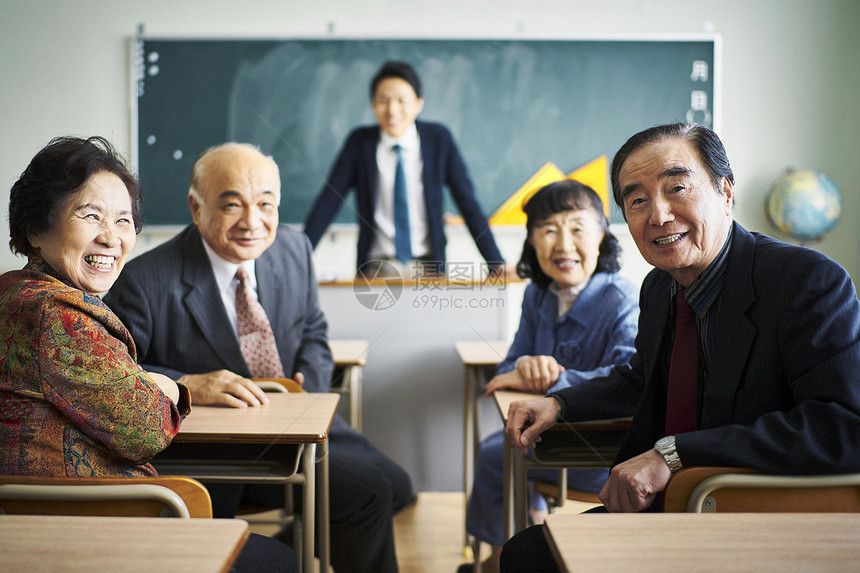 教室里坐着的一群老人看着镜头微笑图片