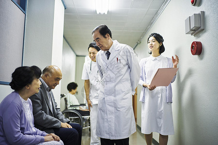 在医院走廊三个医护人员在和病人交谈图片