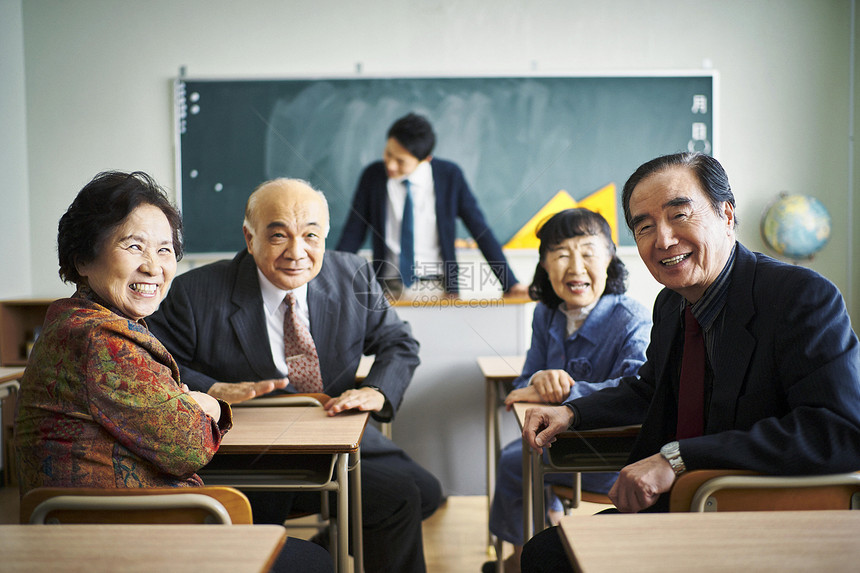 教室里坐着的一群老人看着镜头微笑图片