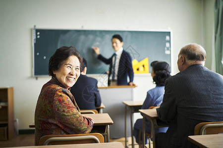 终身的老年人在教室里开怀大笑背景