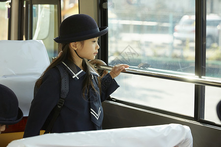 乘坐校园巴士的小女孩在看窗外图片