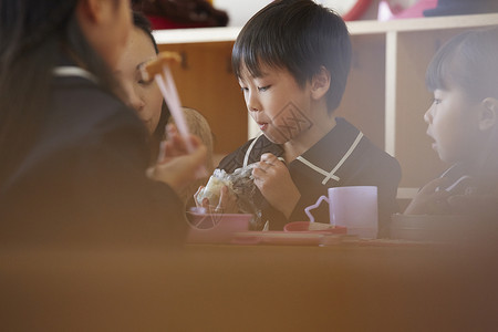 在午餐时间老师看着小朋友吃饭图片