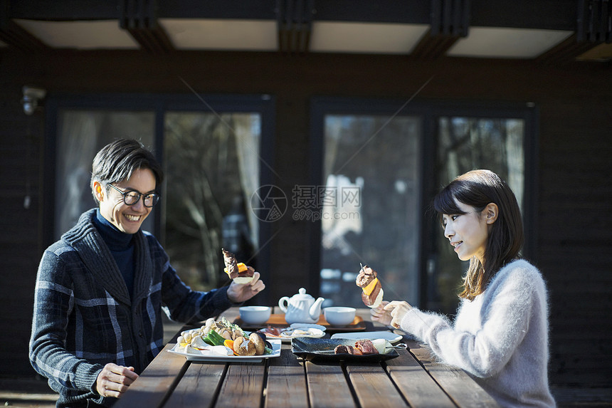 年轻情侣在户外吃烧烤图片