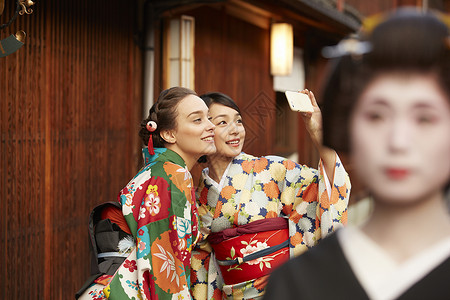 合影的游客路过日本传统歌舞艺妓图片