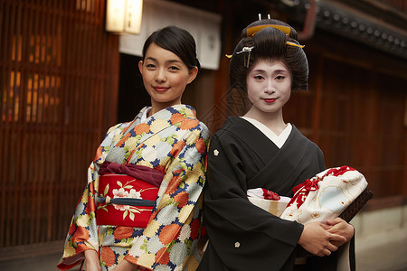 穿着和服的日本女人与艺伎看着镜头背景图片