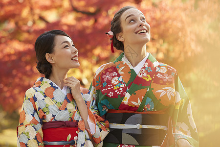 日本秋叶和服女人带领外国游客观赏红枫叶背景