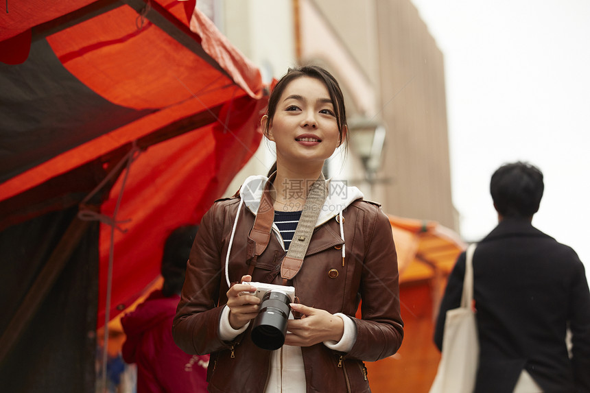 女孩在早晨集市观光拍照图片