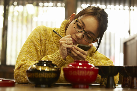 体验漆器制作的女人背景图片