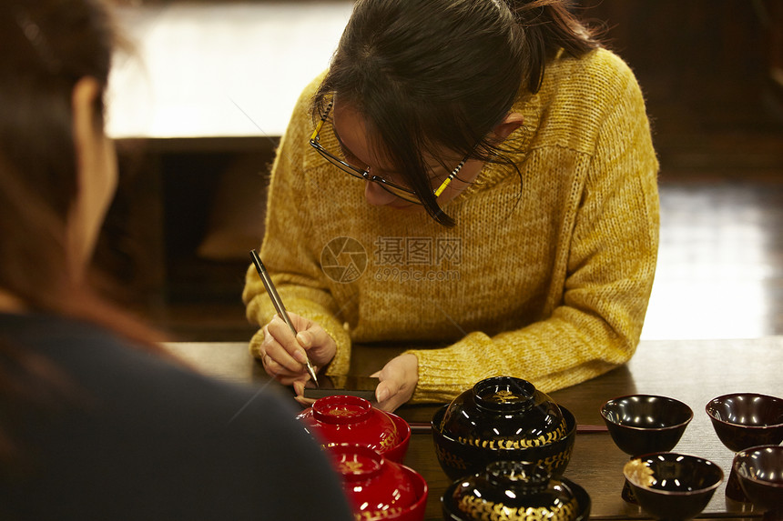 体验漆器制作的女人图片