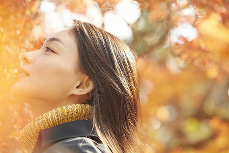 年轻女人观赏秋天枫叶图片