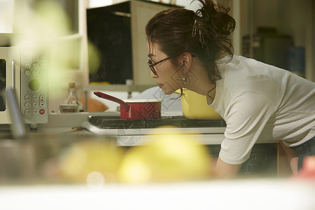 在窗边料理台制作午饭的女人背景图片