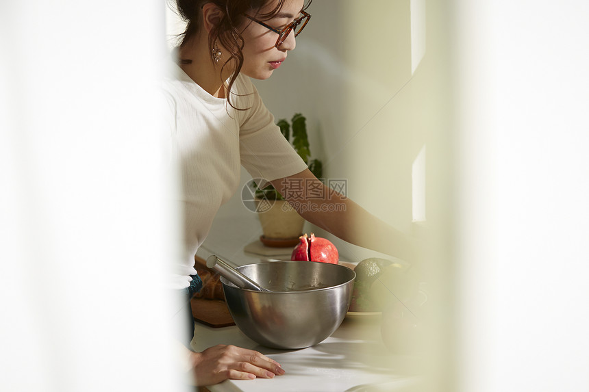 在窗边料理台制作午饭的女人图片