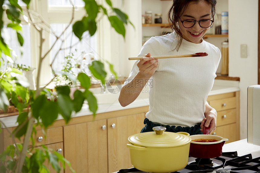 在窗边料理台制作午饭的女人图片