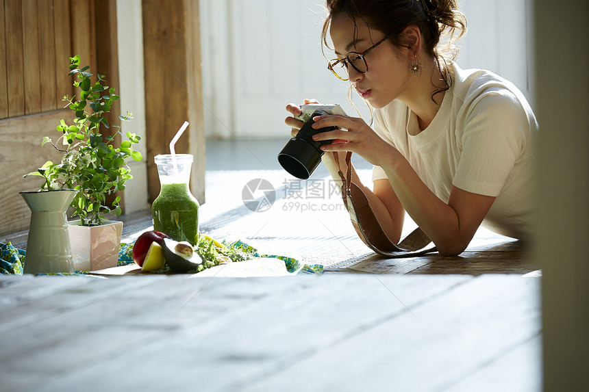 在客厅拍摄美食的时髦美女图片