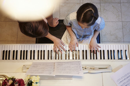 演奏钢琴女孩老师在指导女孩练钢琴背景