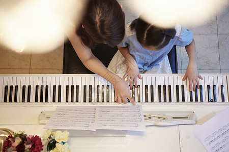 钢琴课老师在指导女孩练钢琴背景