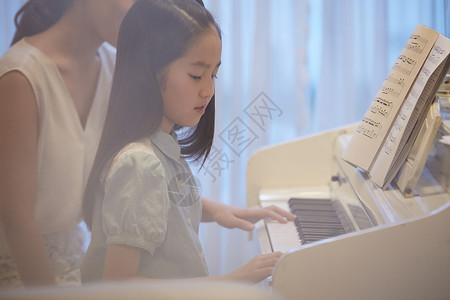 钢琴老师在指导女孩练琴图片