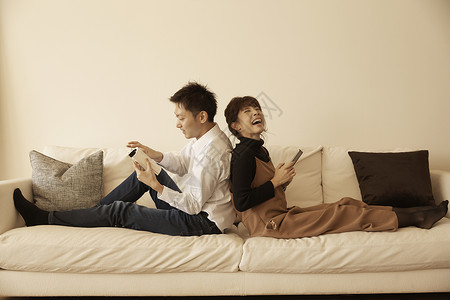 在公寓沙发上放松玩闹的夫妇高清图片