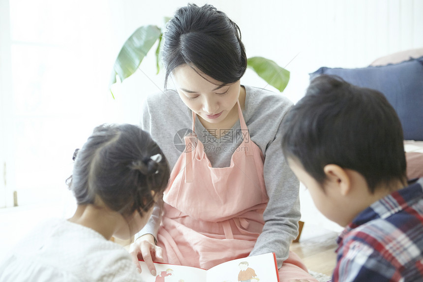 保育员在和孩子一起看书图片