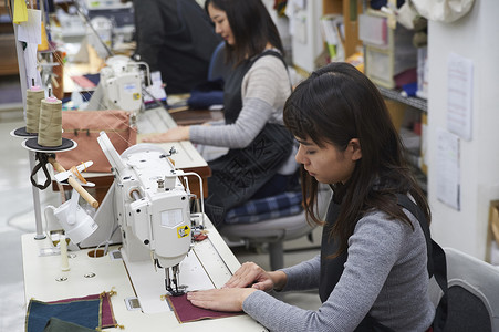 在制作手提包的女缝纫工工作室高清图片素材