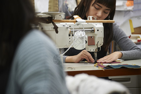 在制作手提包的女缝纫工全力以赴高清图片素材