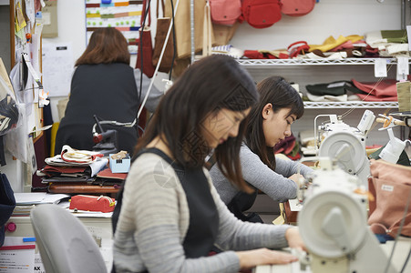 在制作手提包的女缝纫工室内高清图片素材